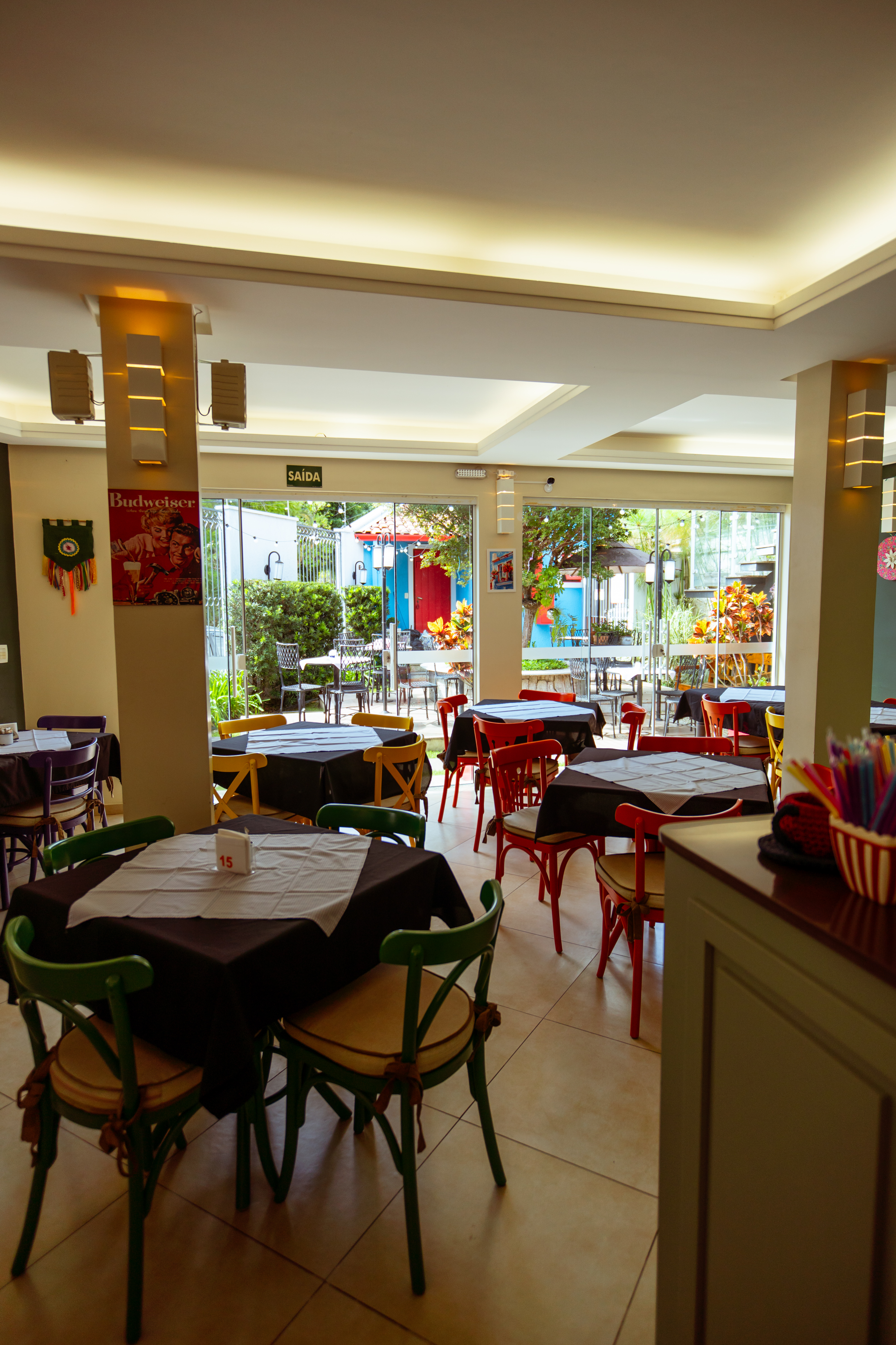 Salão do restaurante com mesas e cadeiras coloridas
