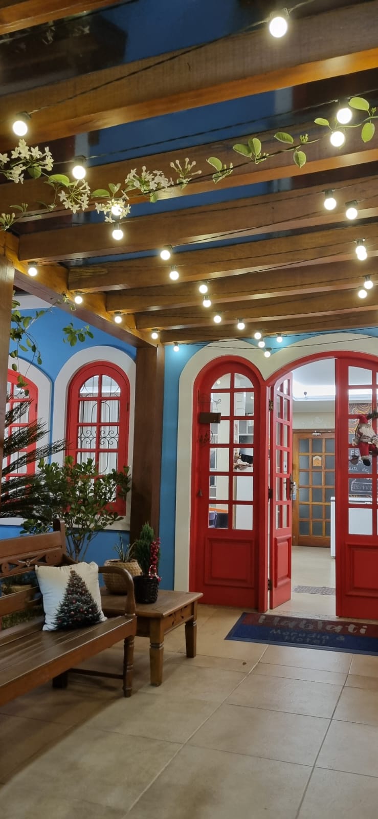 Varanda coberta com luzes e portas vermelhas em arco