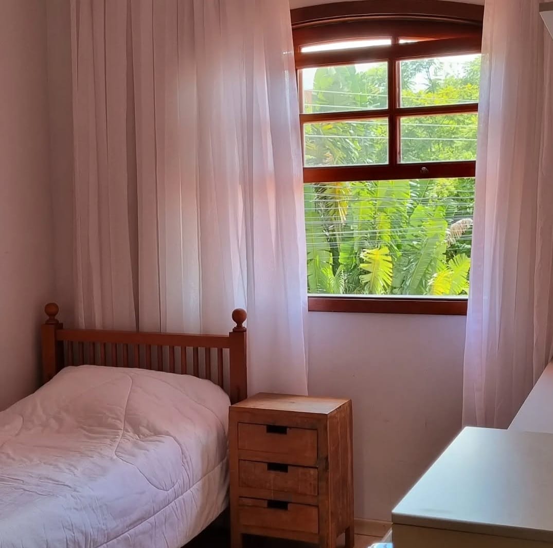 Quarto solteiro com janela e vista para o jardim
