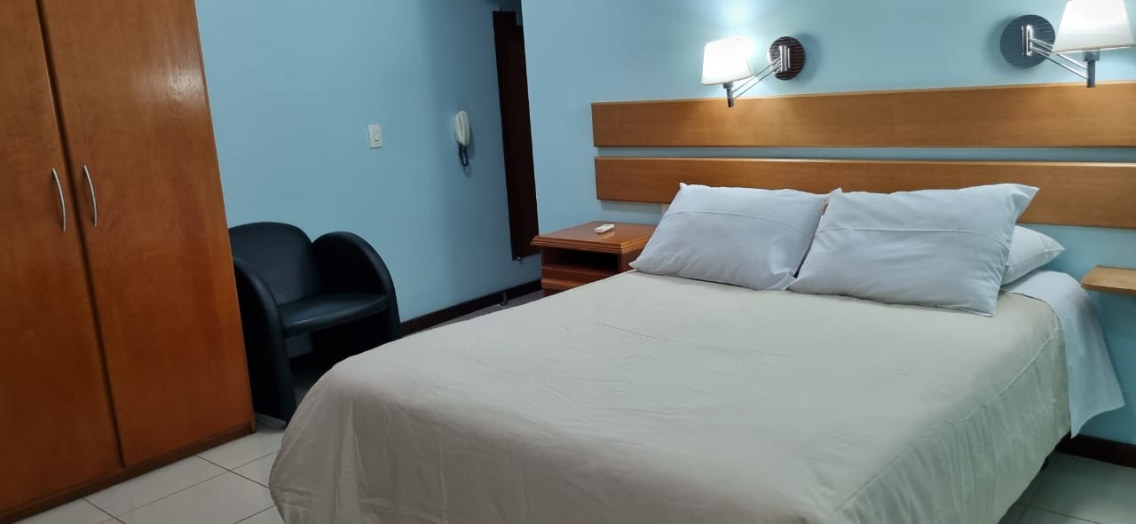 Quarto de casal com cabeceira de madeira clara