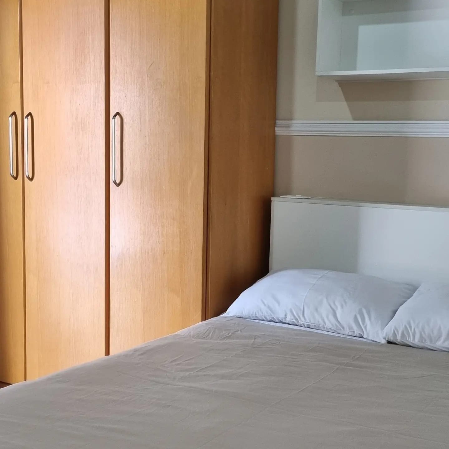Quarto amplo com guarda-roupa em madeira
